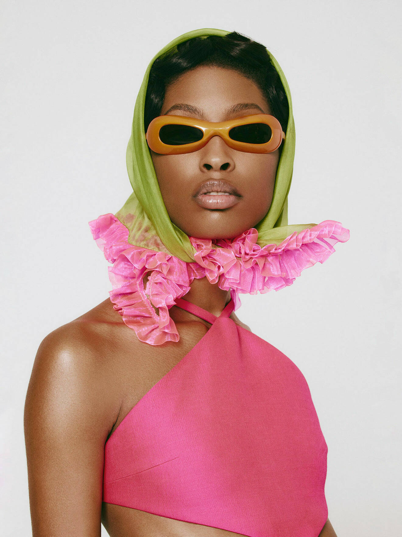 Modellen har på sig en rosa topp från Valentino tillsammans med en grön scarf från Bora Aksu