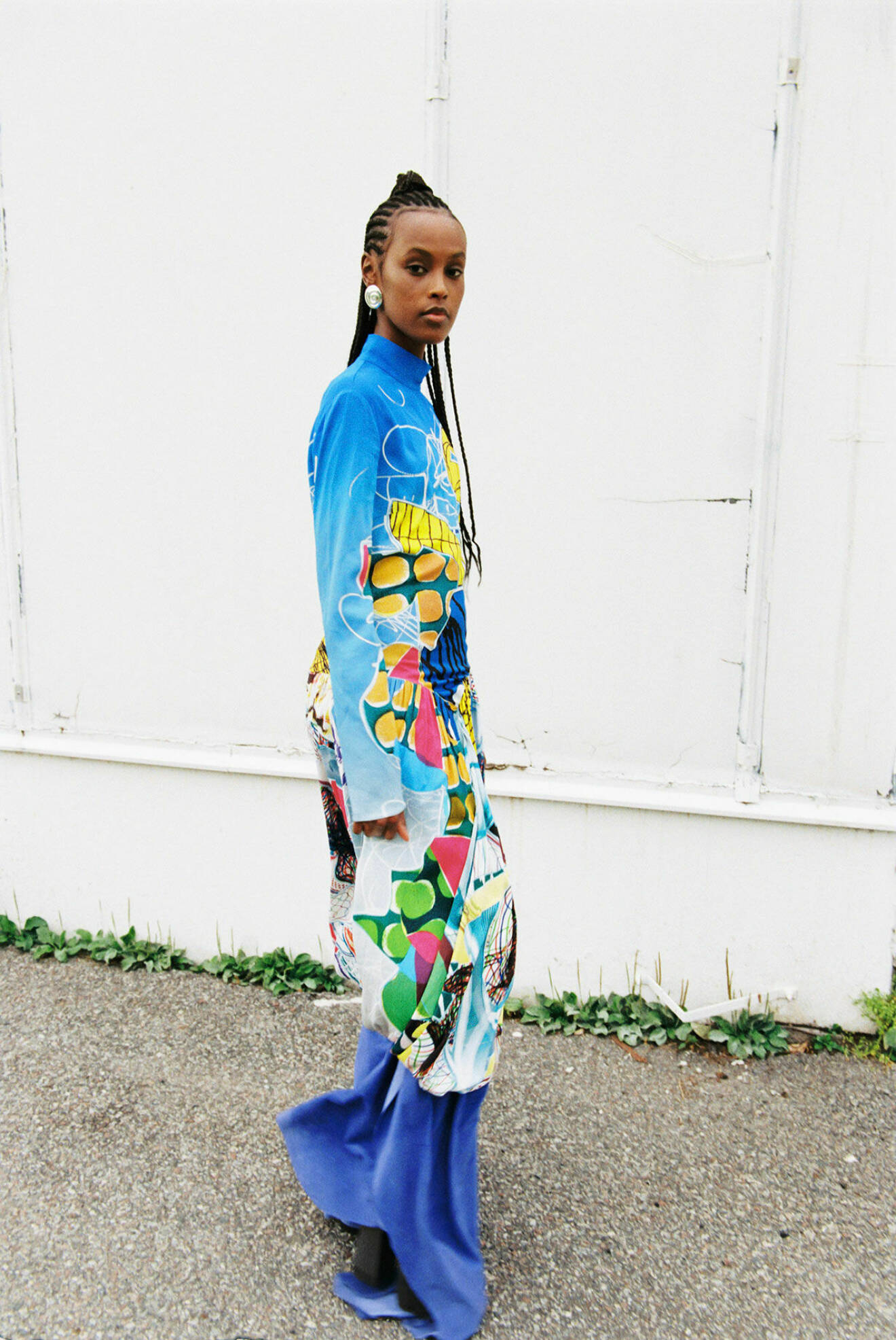 Fotomodellen har på sig en långklänning i blått med mönster från Stella McCartney.