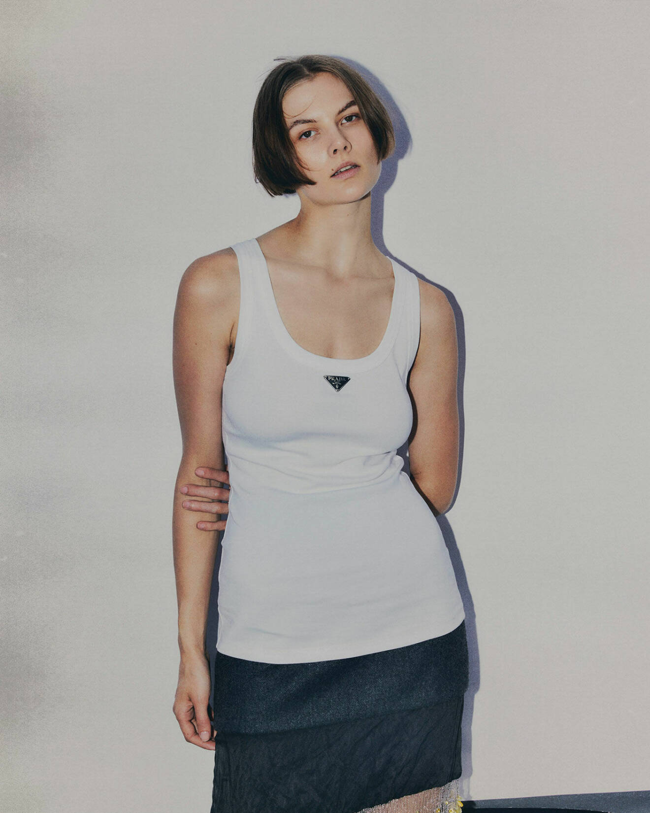 Fotomodellen bär ett vitt linne och kjol från Prada