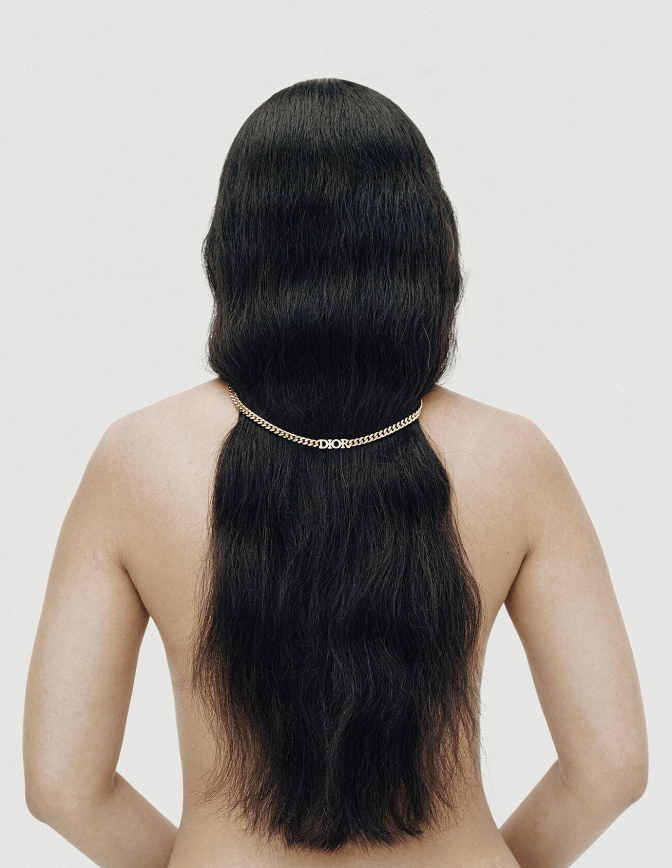 Modellen har på sig ett halsband över håret från Dior.