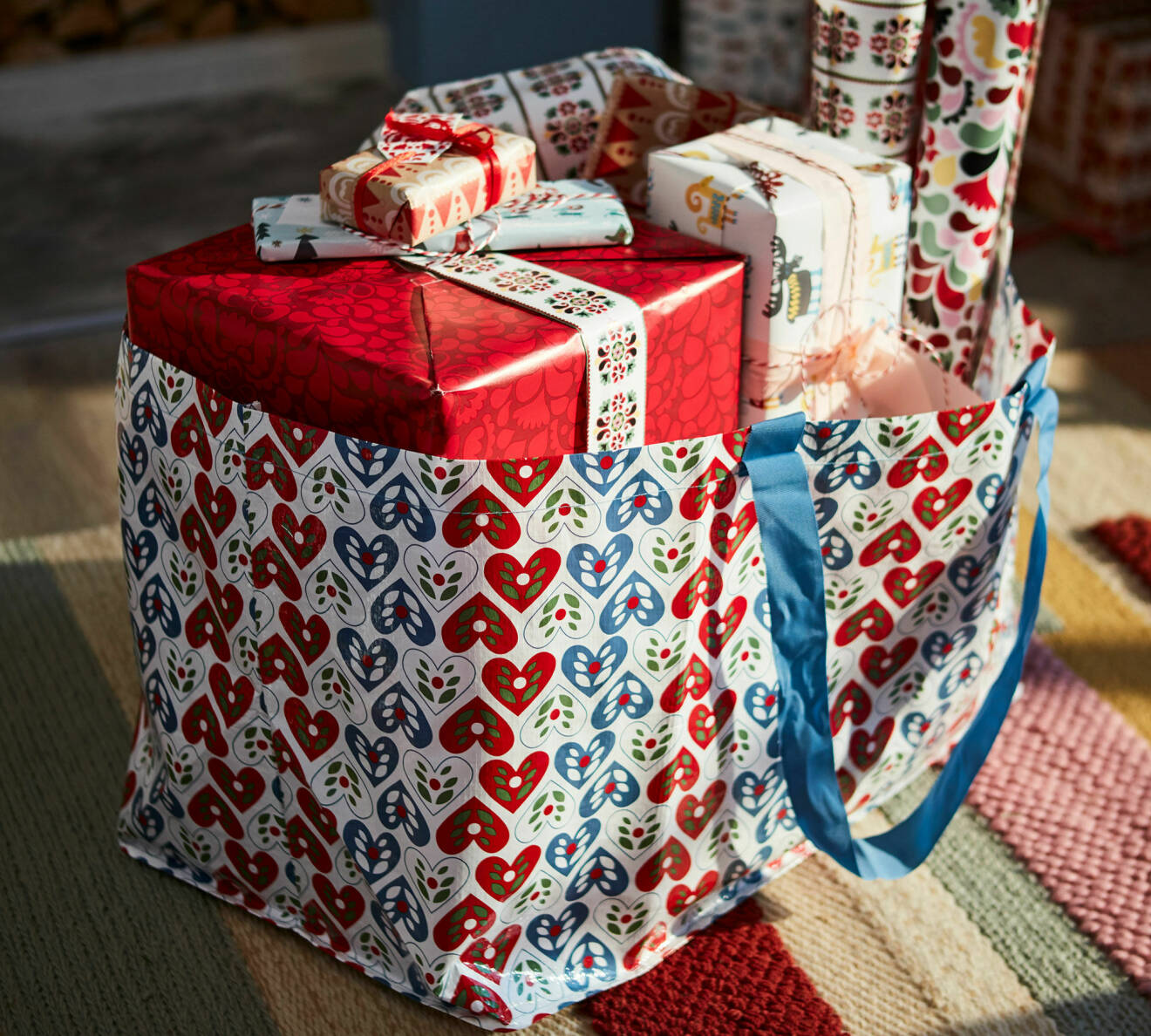 Ikea-kasse med ett julprint och fylld med julklappar och presentpapper från årets kollektion