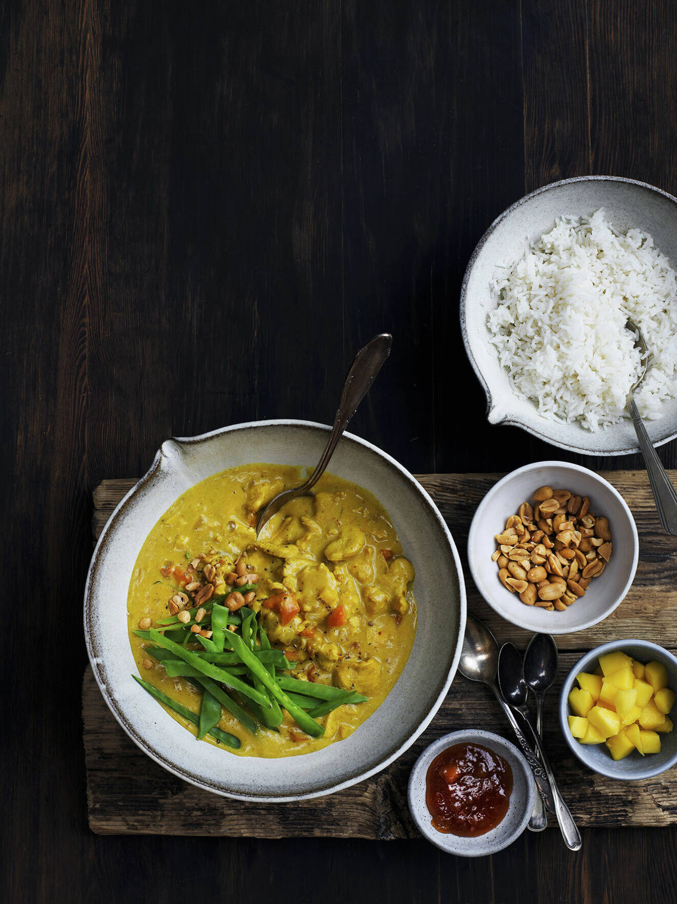 Bjud på en värmande kyckling i curry med mango, sockerärter och jordnötter