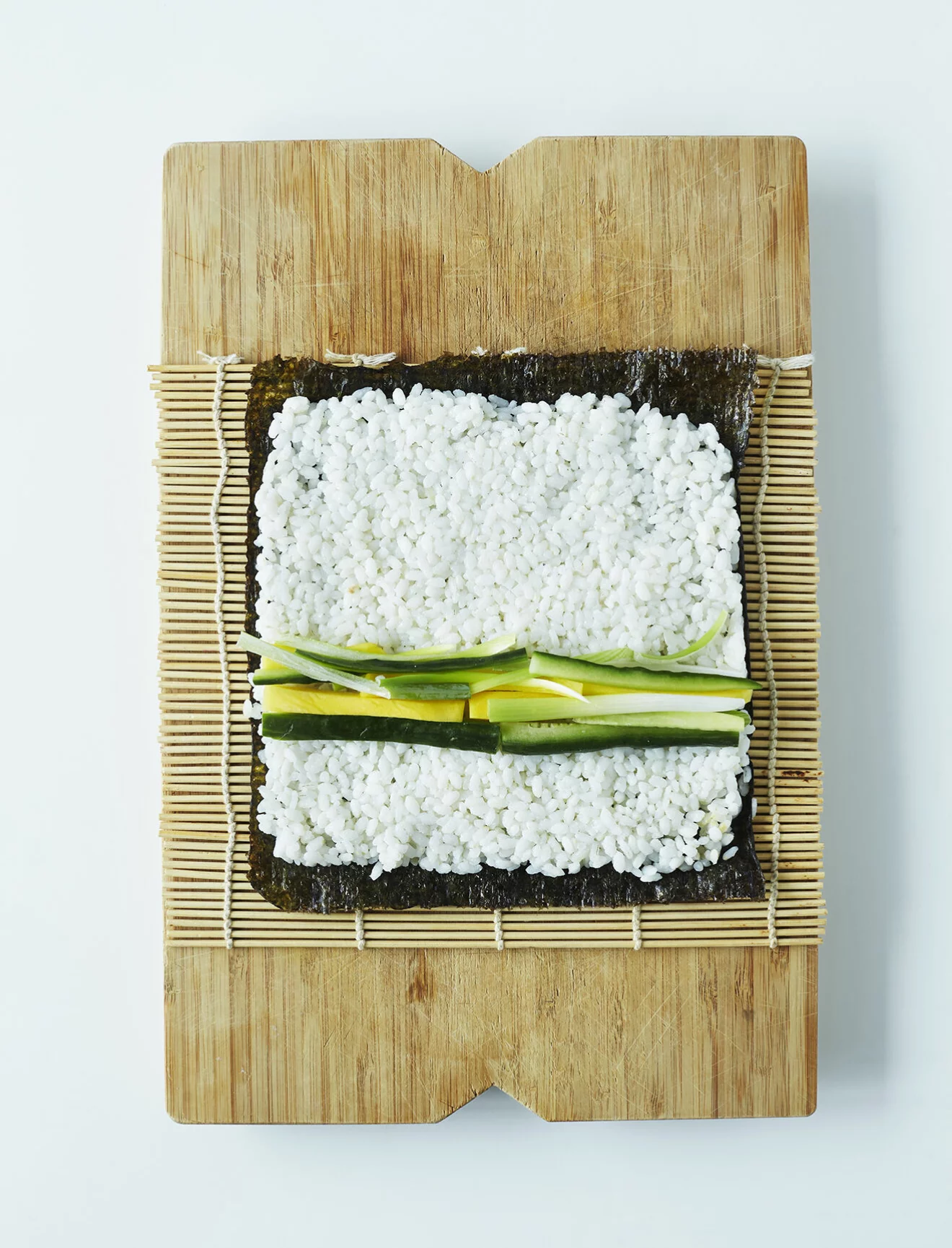 Steg 3 – Fördela ris i ett jämnt lager på noribladet och fördela fyllningen över mitten.