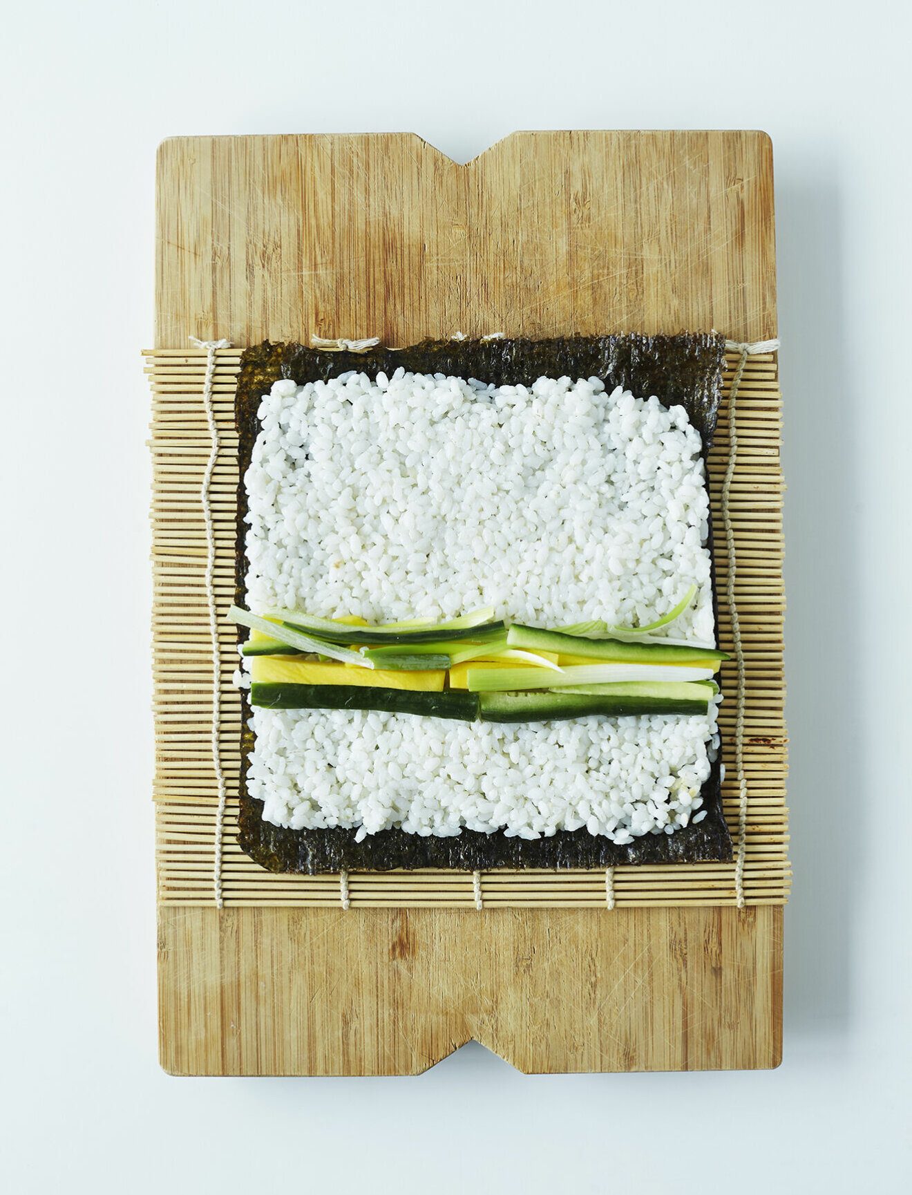 Steg 3 – Fördela ris i ett jämnt lager på noribladet och fördela fyllningen över mitten.