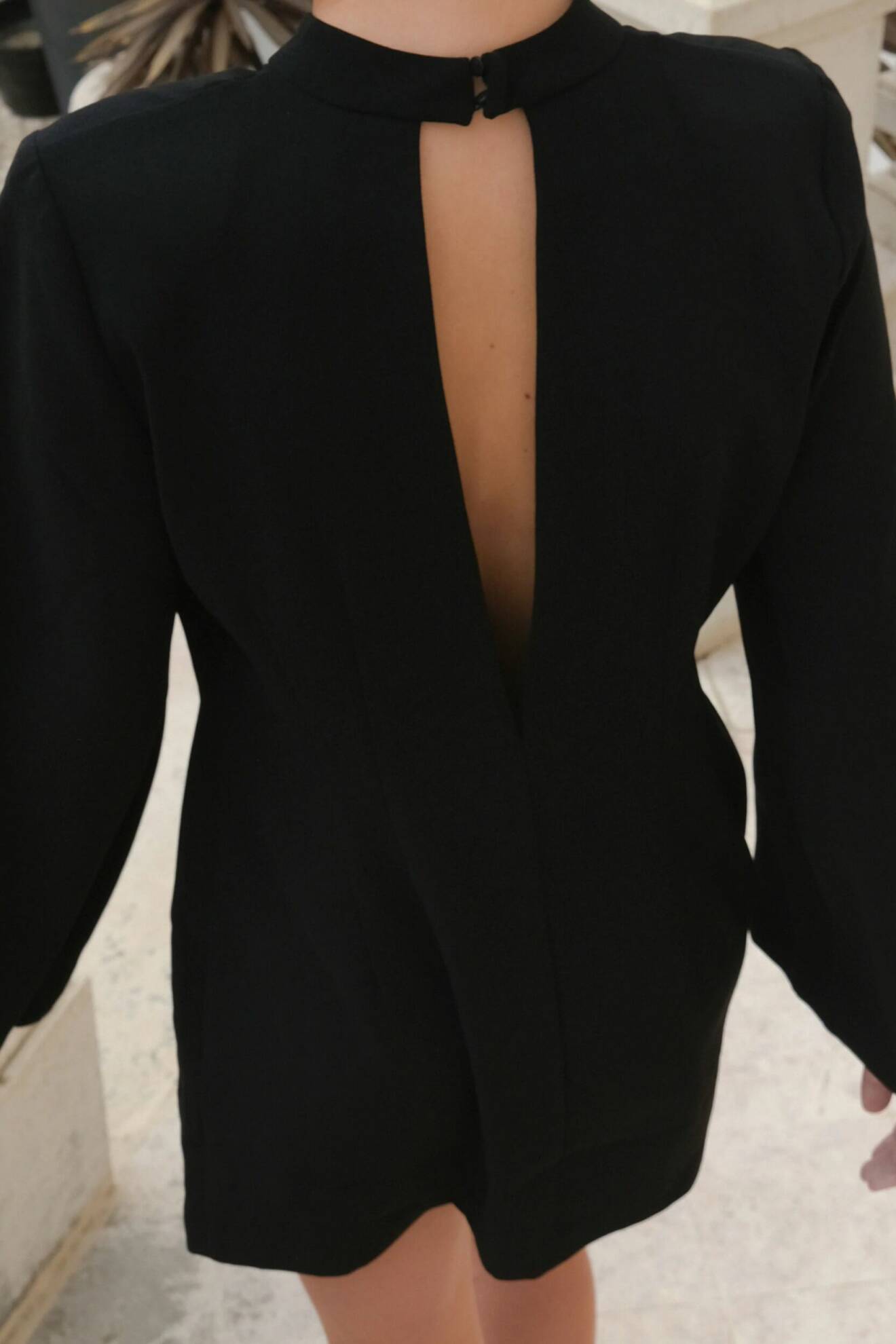 Spana in denna svarta klänning med öppen ryggdetalj och vida ärmar från Stylein.