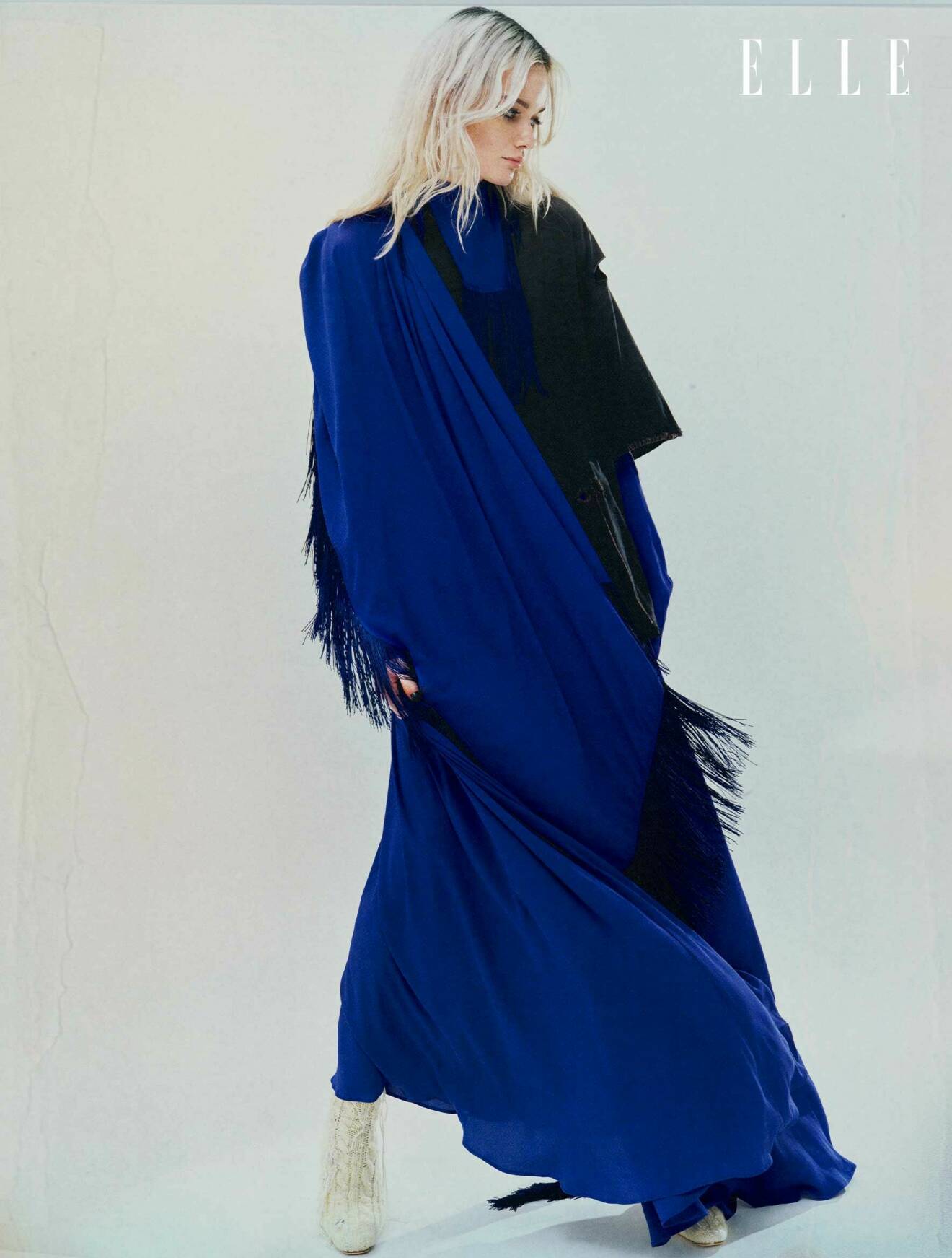 Modellen bär en långklänning i blått med fransar från Acne Studios.