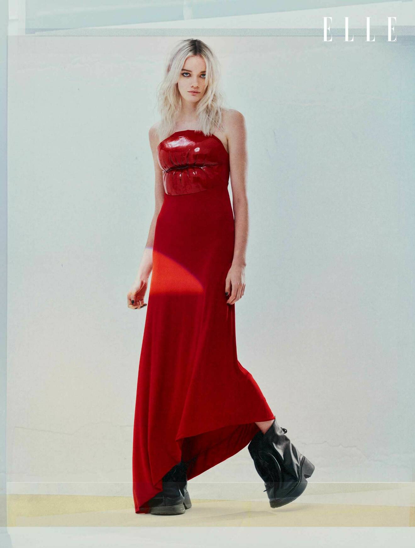Modellen bär en lång röd klänning med mönster av en mun upp till, från Loewe.