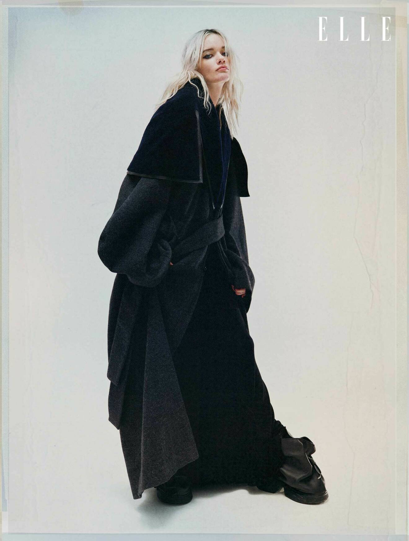 Modellen bär en grå kappa, svart kjol och svarta skor, allt från Loewe.