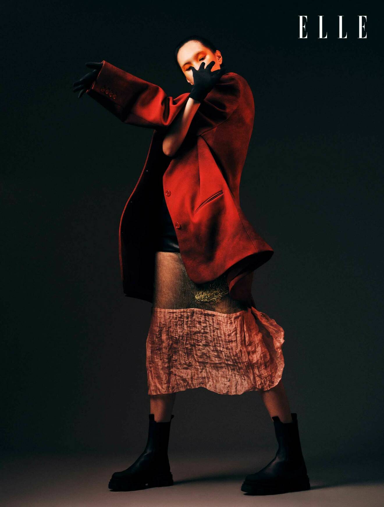 Fotomodellen bär en röd kavaj från Acne Studios, samt shorts och rosa kjol från Prada.