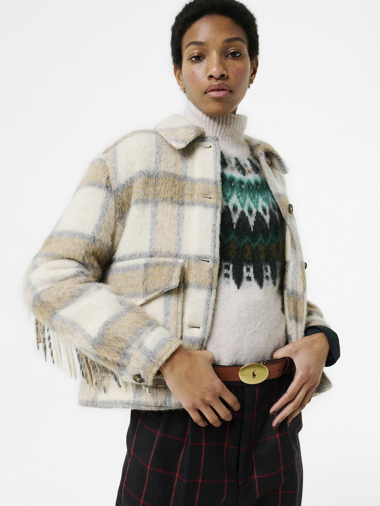 Modellen bär en rutig jacka från Woolrich, en stickad polotröja med mönster från Marc O'Polo och rutiga ullbyxor från Gucci.