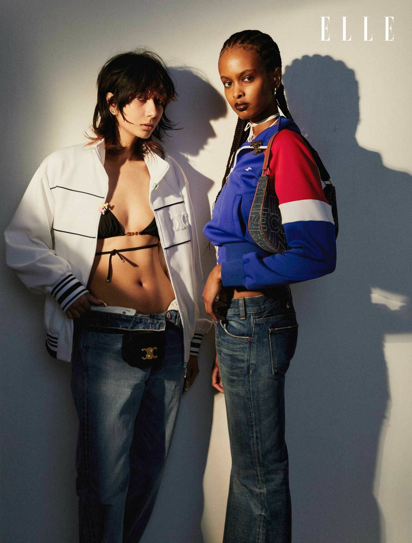 Sabina till vänster har på sig en vit jacka med en svart bikinitopp under och ett par jeans. Ikra till höger har på sig en jacka i blått, rött och vitt tillsammans med jeans.