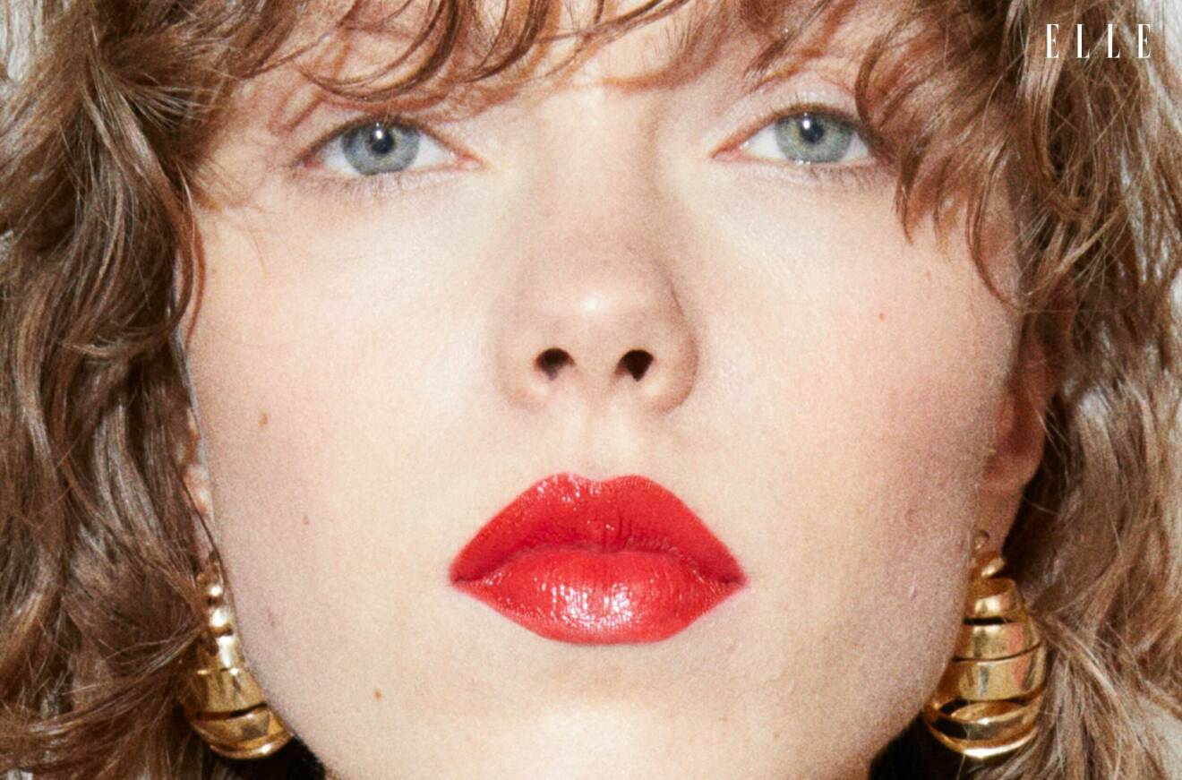 Närbild på modellen ansikte, hon bär stora guldiga örhängen från Bottega Veneta.