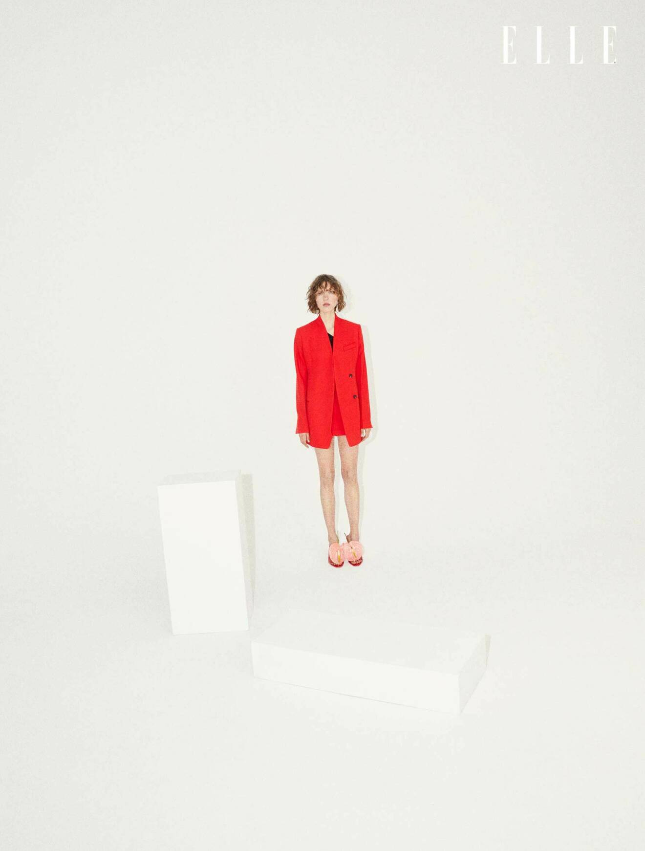 Modellen har på sig en röd kavaj, kjol och skor, allt från Salvatore Ferragamo.