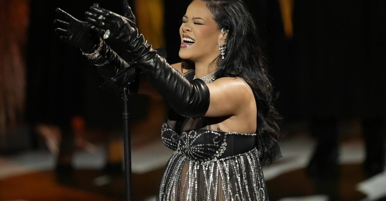 Rihanna i halterneck topp i tyll och krisatller. Svarta handskar med ring och armband. Hon bär diamant örhängen och halsband