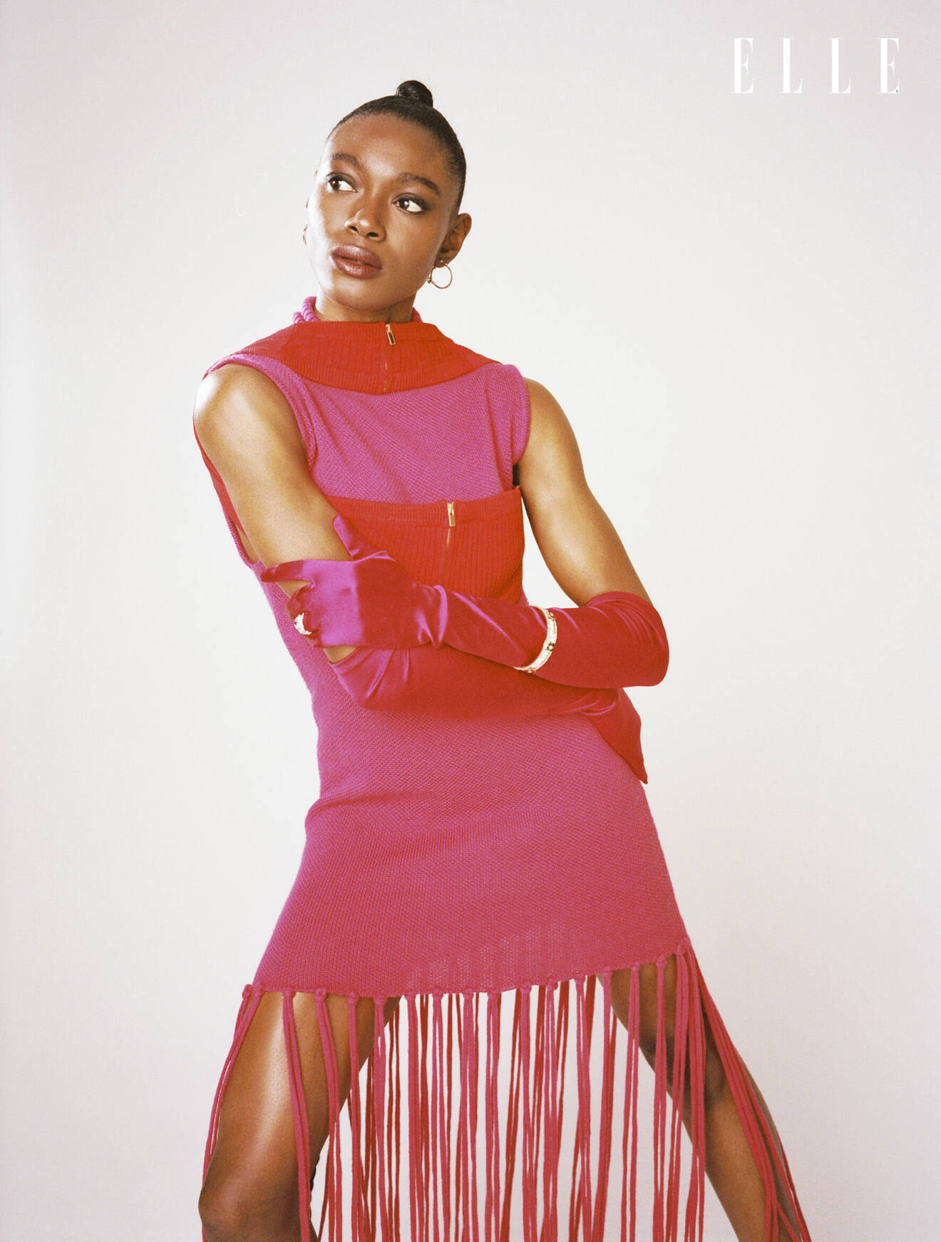 Fotomodellen bär en rosa klänning från Thebe Magugu tillsammans med mörkrosa sidenhandskar från Lotta Vintage.