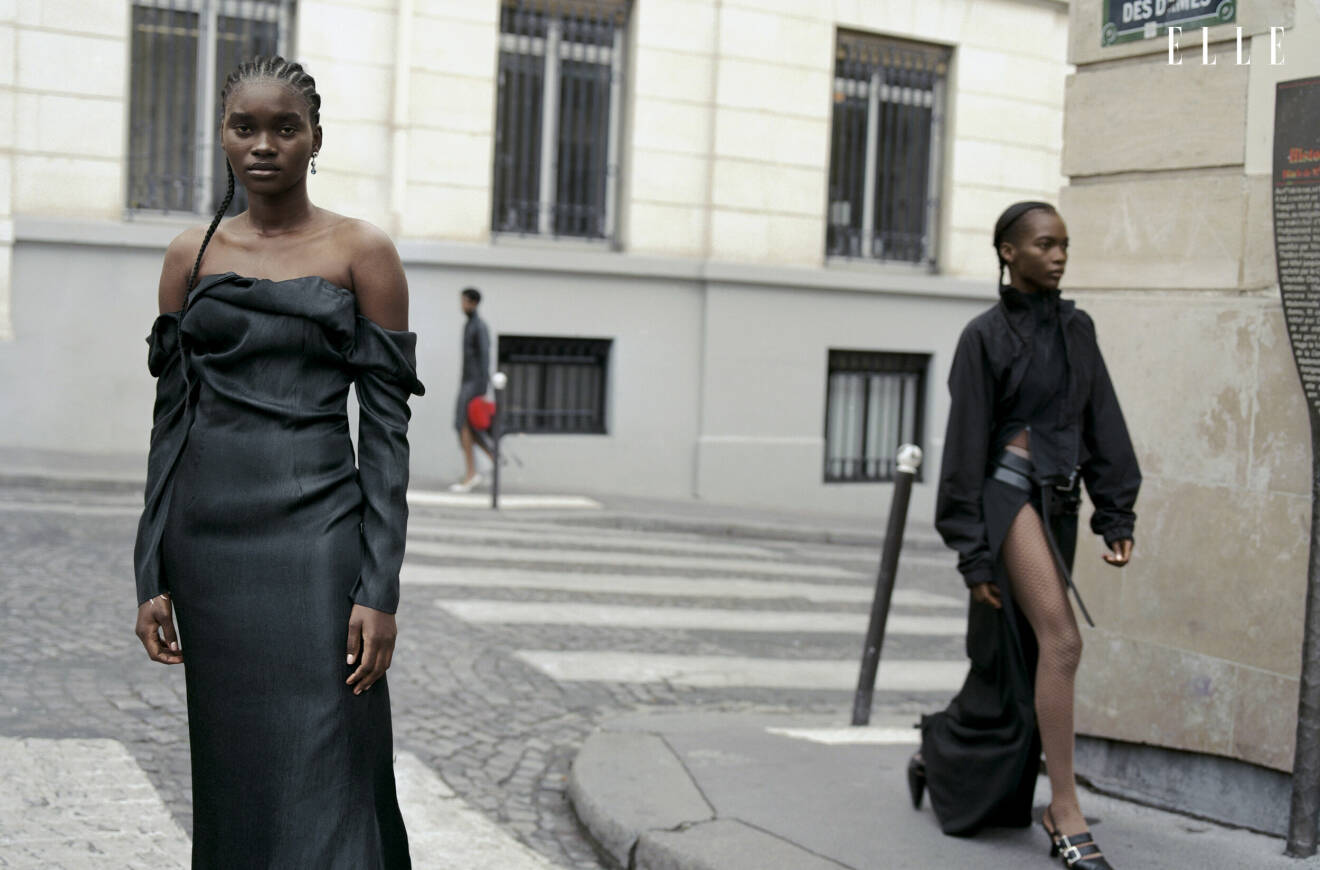 Fotomodellen till vänster har på sig klänning med långa armar och bara axlar och modellen till höger har på sig en svart jacka och kjol med hög slits, allt från Jade Cropper.