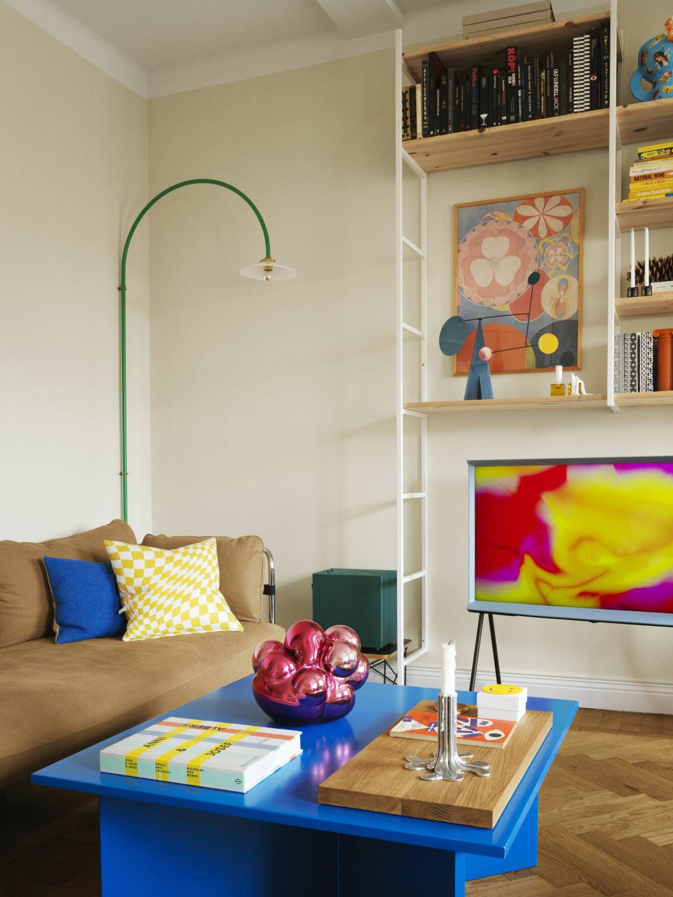 färgglatt vardagsrum med soffbord, soffa och vägglampa