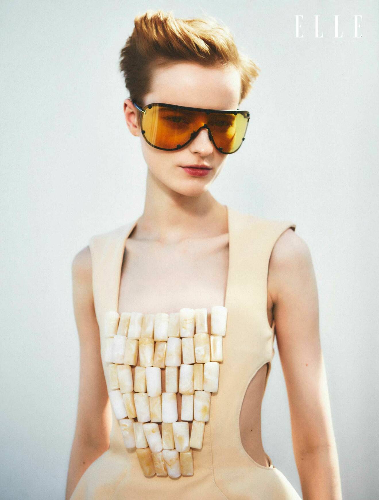 Fotomodellen bär stora solglasögon från Tom Ford och en beige topp från Awake Mode