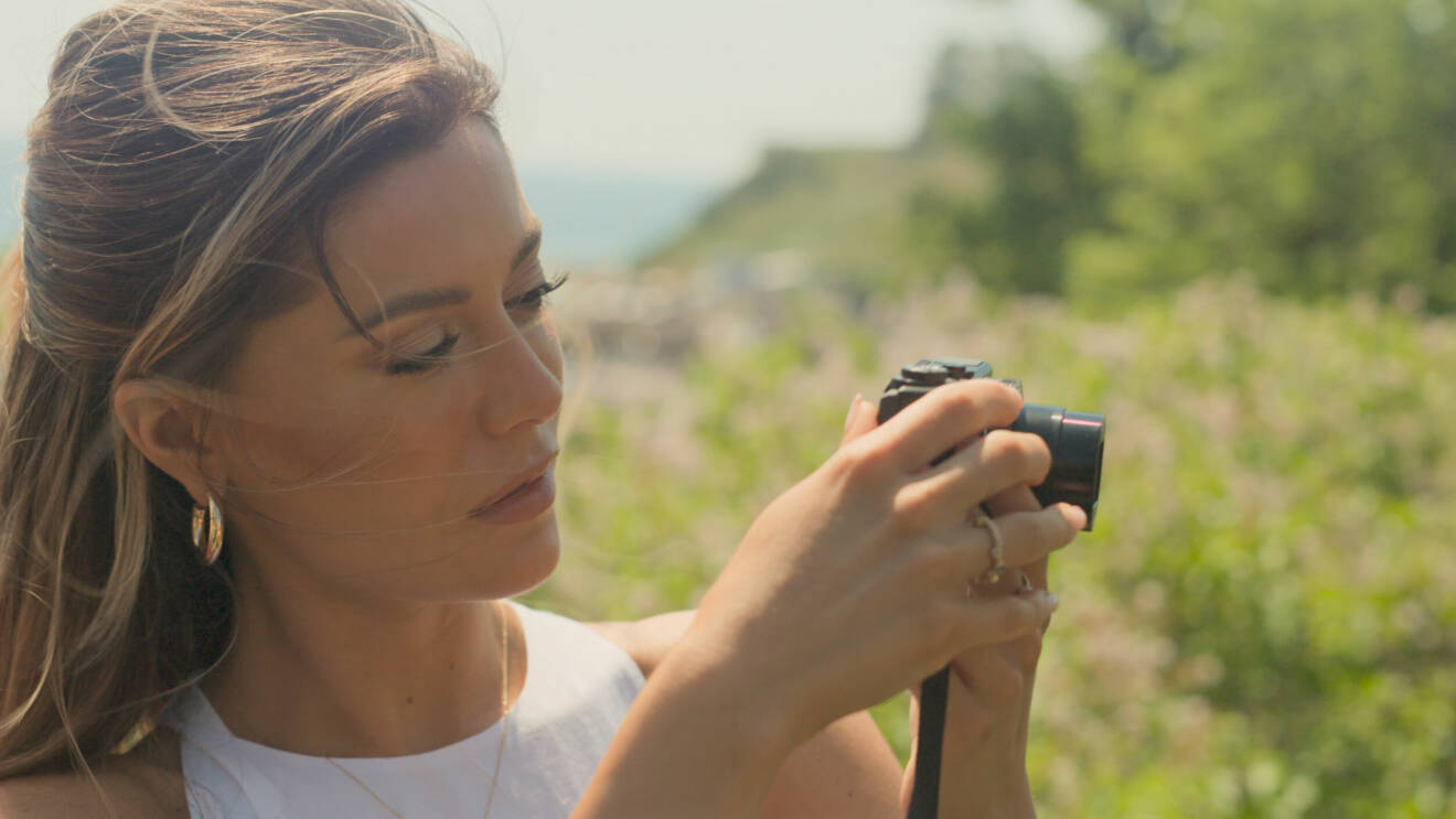 Bianca Ingrosso håller i en kamera på en sommaräng