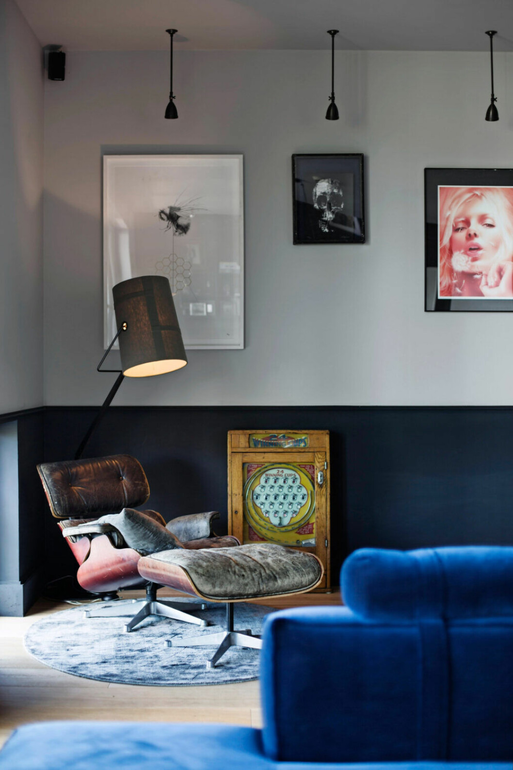 Ombonad hörna i blåa toner med fåtölj och lampa i industriell stil