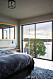 Sovrum med stort golv till tak fönster och utsikt över vattnet