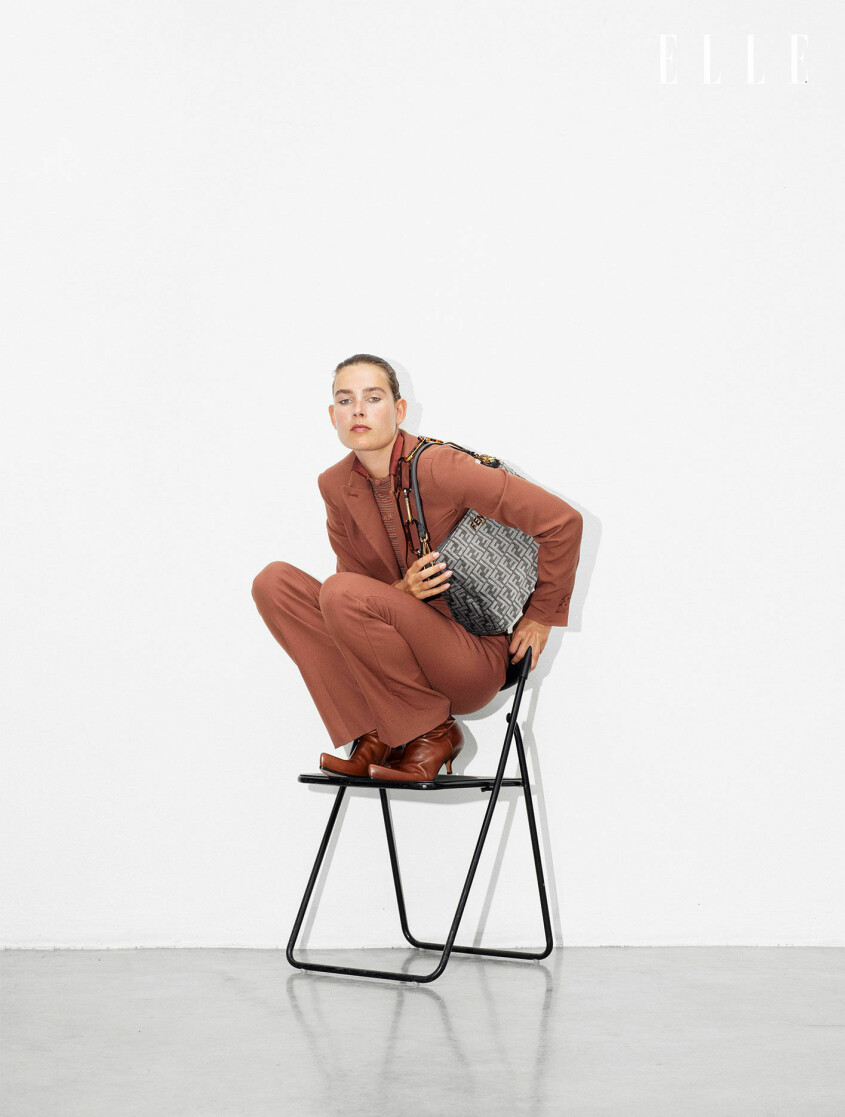 Kavaj, 20 000 kr, byxor, 7 900 kr, skjorta, pris vid beställning, och väska, 26 000 kr, allt Fendi. Stövlar, 6 030 kr, Sportmax. Modellen sitter på huk på en stol och hon har på sig en brun kavaj med matchande byxor till, allt från Fendi.
