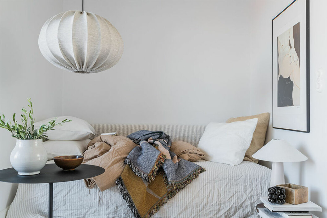 Dagtid förvandlas sängen till en soffa med textilier och prydnadskuddar. Foto: Annie Hyrefeldt Styling: Emma Fischer/Emma Hos för Alvhem/mäklare: Christina Arnesdotter Kombinera soffa och säng i ett i den lilla bostaden