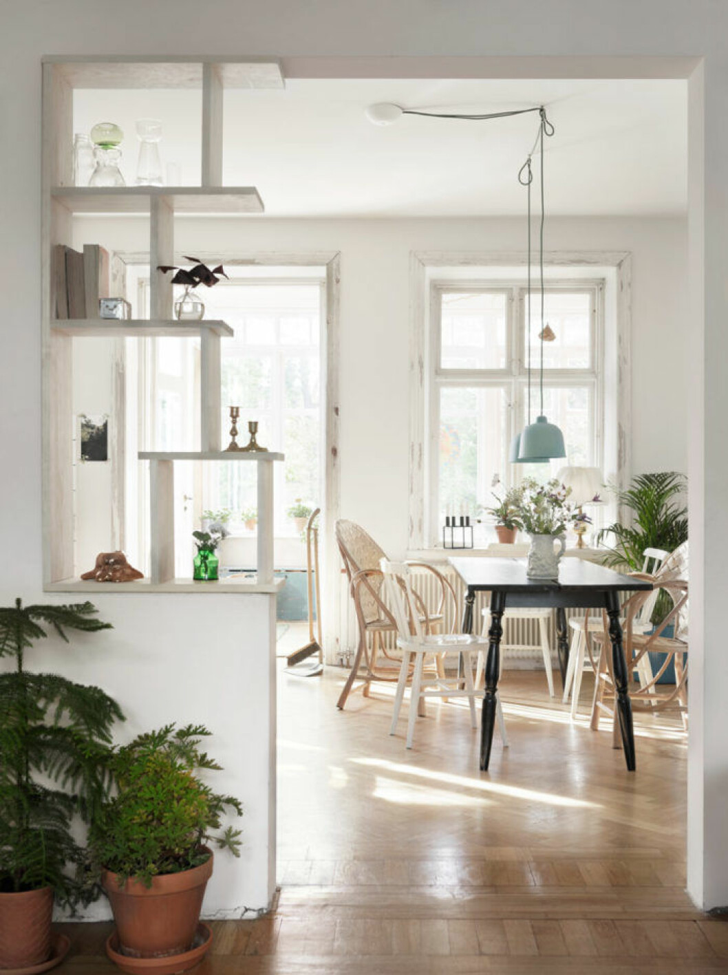 Matplats med svart matbord och stolar i vitt och trä
