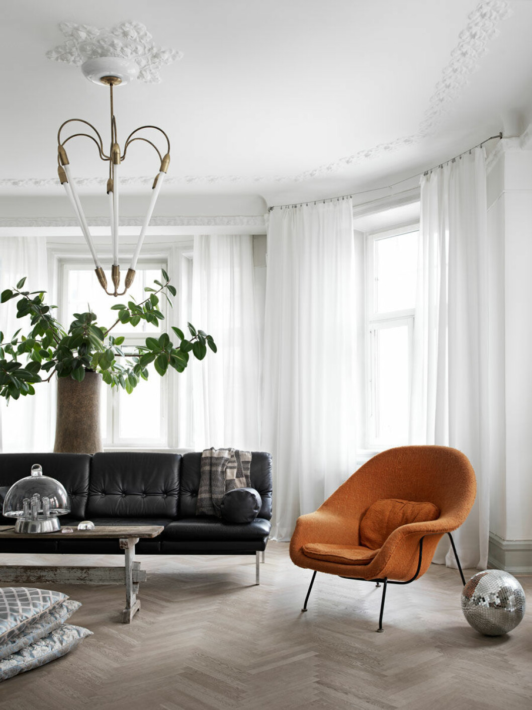 Foto: Marcus Lawett, styling: Karolina Vertus. Syns i: ”Magisk drömlägenhet fylld med personlig och stilsäker inredning”. Svart skinnsoffa och orange fåtölj