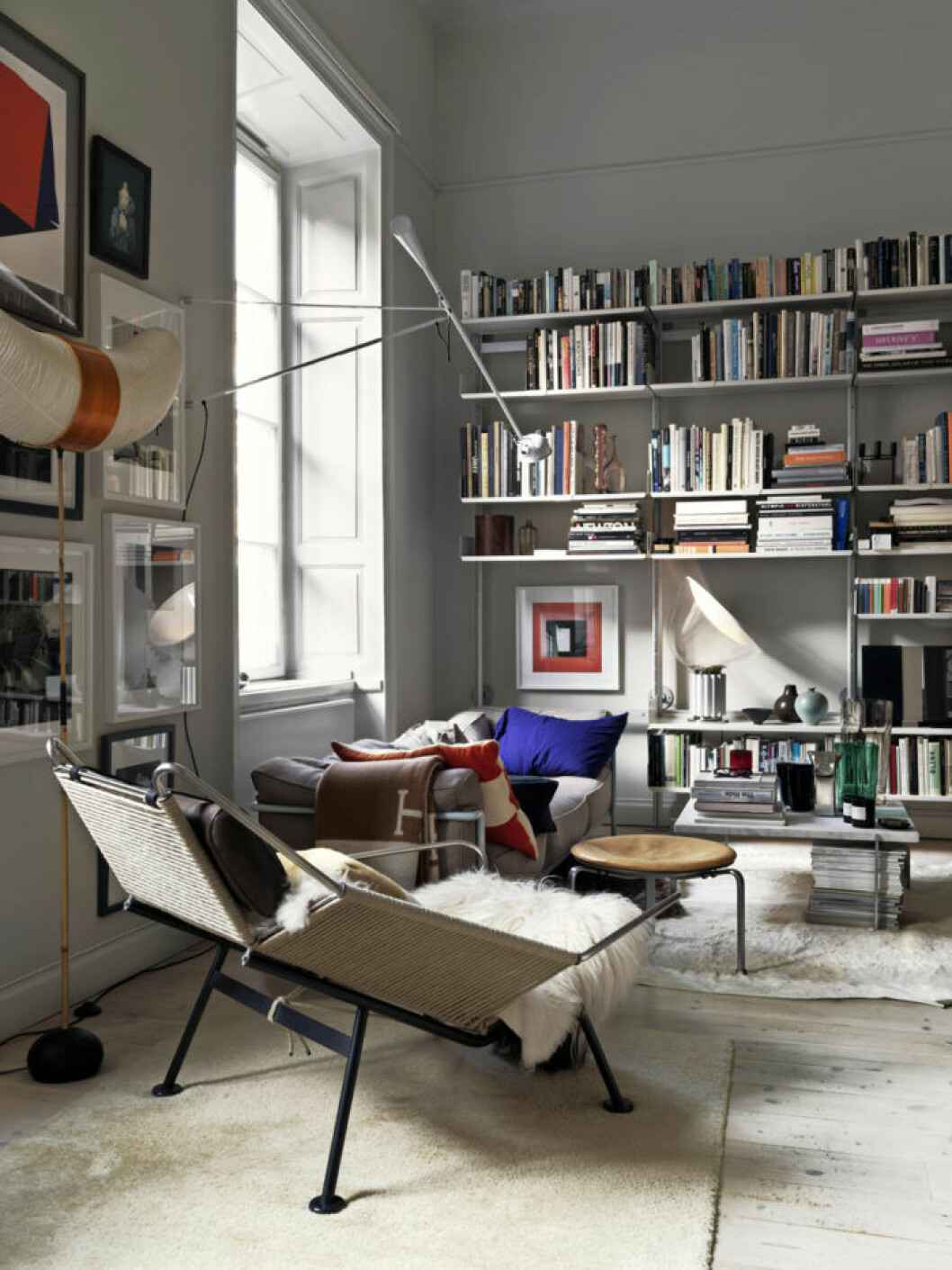 Foto: <a href="http://ingerstedt.se/">Jonas Ingerstedt</a> Vardagsrum med bokhylla, design fåtölj, tavelvägg
