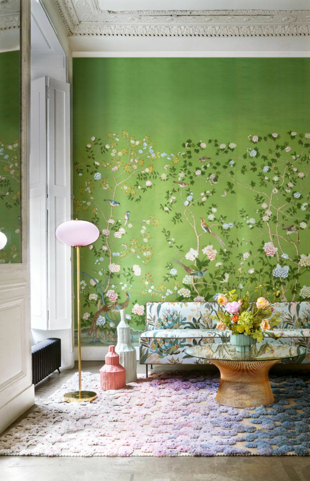 Limegrön tapet med pastellfärgade blommor och pastellfärgad matta