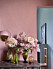 Rosa vägg, rosa bordslampa, stor bukett med rosa blommor