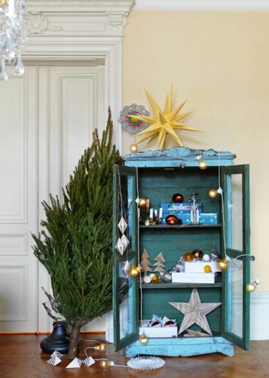 <strong>Julförberedelser</strong><br>Skåp, 9 450 kr, Raja. Adventsstjärna, 60 cm, 425 kr, julgransfot, 2 100 kr, och änglaspel, 139 kr, Byggfabriken. Toppstjärna, design Tor Cederman, 695 kr, Svensk Slöjd. Ljusslinga, 449 kr, Granit. Antika julkulor, 35–65 kr/st, Raja. Trägranar, ca 900 kr/3 st, och trästjärna, ca 600 kr, Andra Brugi. Handgjorda pappershängen <em>Diamond</em>, ca 54 kr/st, och vit snöflinga i papp, ca 27 kr, Rie Elise Larsen. Julpynt-inspiration-julgran
