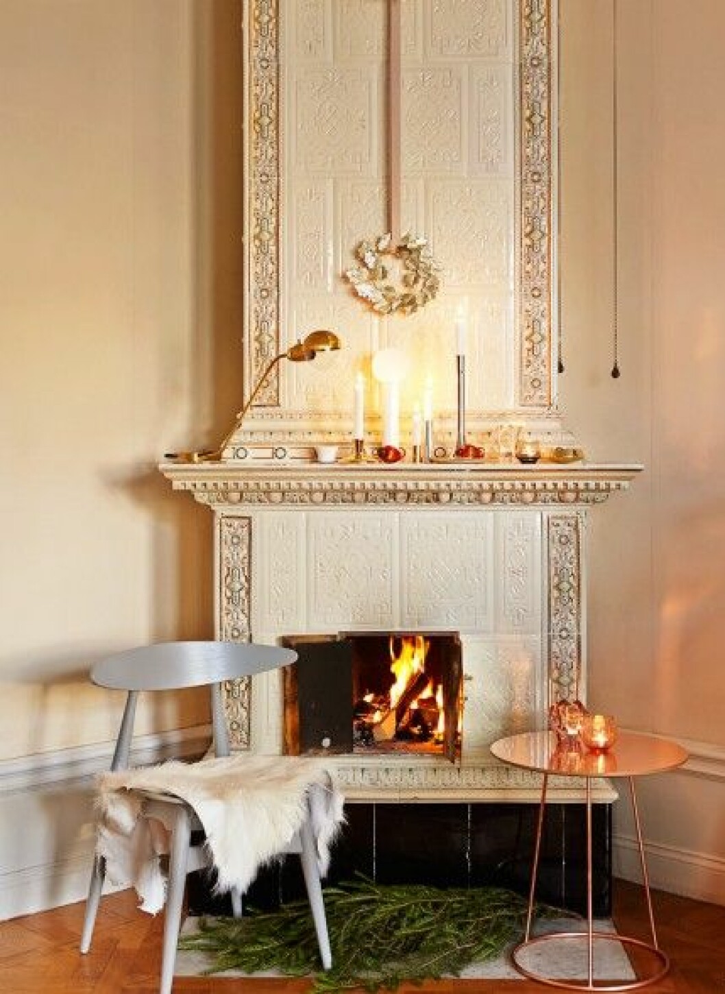 <strong>Samlas kring brasan</strong><br>Krans med guldblad, 250 kr, Svenskt Tenn. Lampa <em>Restart Milano</em>, 3 700 kr, Asplund. Vit ljuslykta <em>Kin</em>, design Claesson Koivisto Rune, 185 kr, och <em>Teaterljustaken</em>, design Thomas Sandell, 498 kr, Skultuna, Ljusstake <em>Swoon</em>, 695 kr, Asplund. Julkula, 35 kr, Raja. Ljushållare, 789 kr/3 st, Petite Friture/NK Glas & Porslin. Ljusstake i tenn <em>Moondrop</em>, design Ingegerd Råman, 3 050 kr, Svenskt Tenn. Ljusslyktor i klarglas <em>Reflection</em>, 329 kr, och i brunt glas <em>Coocon</em>, 99 kr, Holmegaard. Mässingsskål <em>Ballerina</em>, design Claesson Koivisto Rune, 449 kr, Skultuna. Bord <em>Breeze</em>, design Monica Förster, ca 5 279 kr, Swedese. Stol <em>CH 33</em>, design Hans Wegner, ca 5 800 kr, Asplund. Killingskinn, 445 kr, Granbergs garveri/Svensk Hemslöjd. julpynt-julpyssel-inspiration-ljusstakar-kakelugn 122