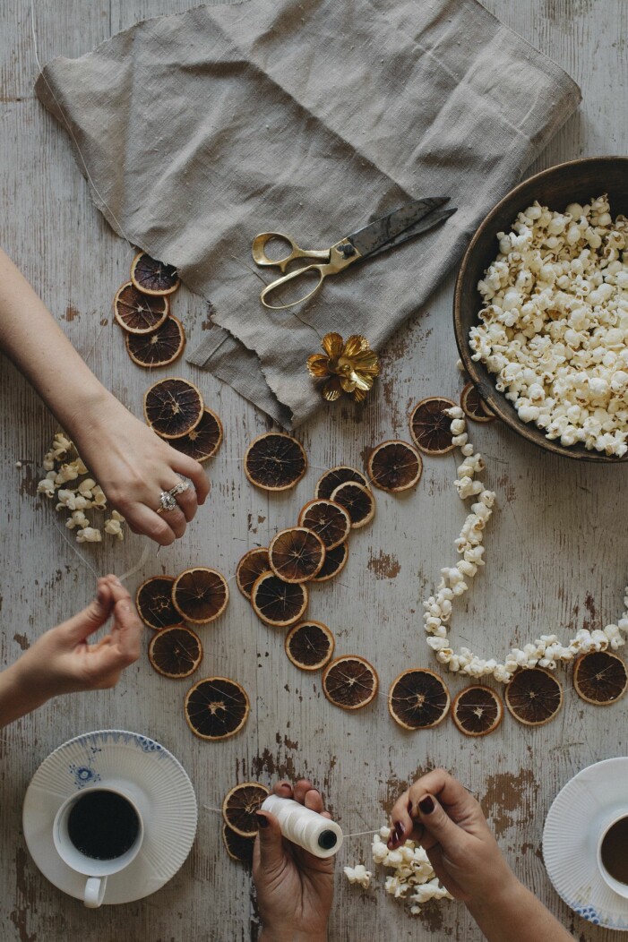 Julpyssel med hamgjorda popcorngirlanger och torkade apelsingirlanger