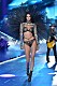 Kendall Jenner går på en catwalk iklädd svarta underkläder och stora svarta vingar på ryggen