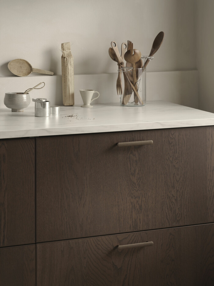 Det mörka träet ger en elegant känsla och fronterna är gjorda av lackerad ekfanér samt massivt trä. kök i mörkbrunt trä från ikea