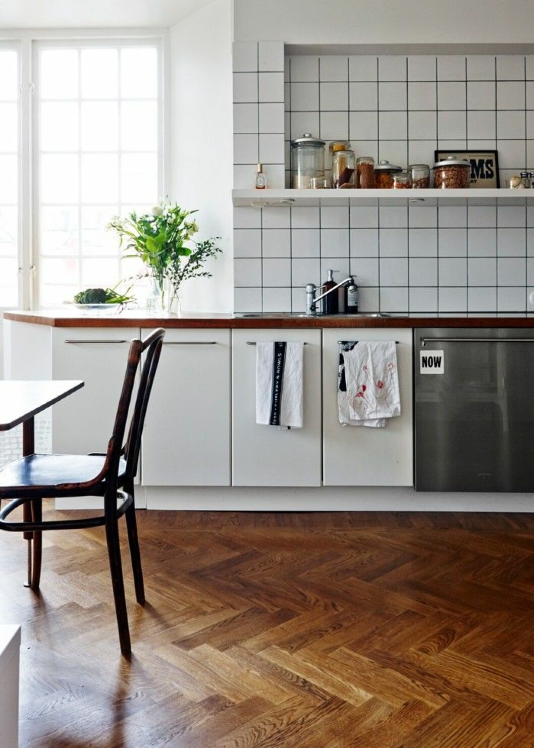 Köket har renoverats med en bas av vitt kakel, vilket för tankarna till en fransk bistro. Handdukar med motiv av Jesper Waldersten, H&M Home. Köket med vitt kakel.