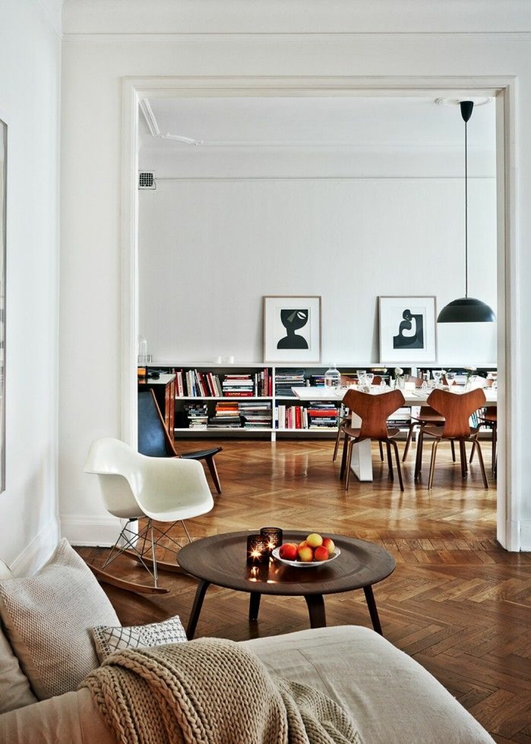 Den låga, platsbyggda bokhyllan var något som Evelina länge drömt om. Hon och maken Stefan Söderberg började samla på klassiska designmöbler av formgivare som Ray och Charles Eames och Arne Jacobsen i början av 90-talet, långt innan den stora boomen på auktionshusen. Gungstol <em>RAR</em>, design Ray och Charles Eames. Den låga bokhyllan är en favorit i hemmet.