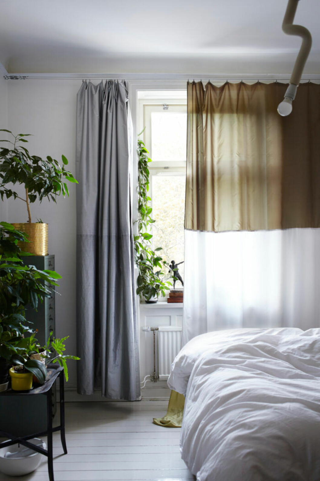 Sovrum i gråa toner med växter och bruna detaljer