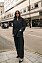 kvinna i svart kostym street style i London