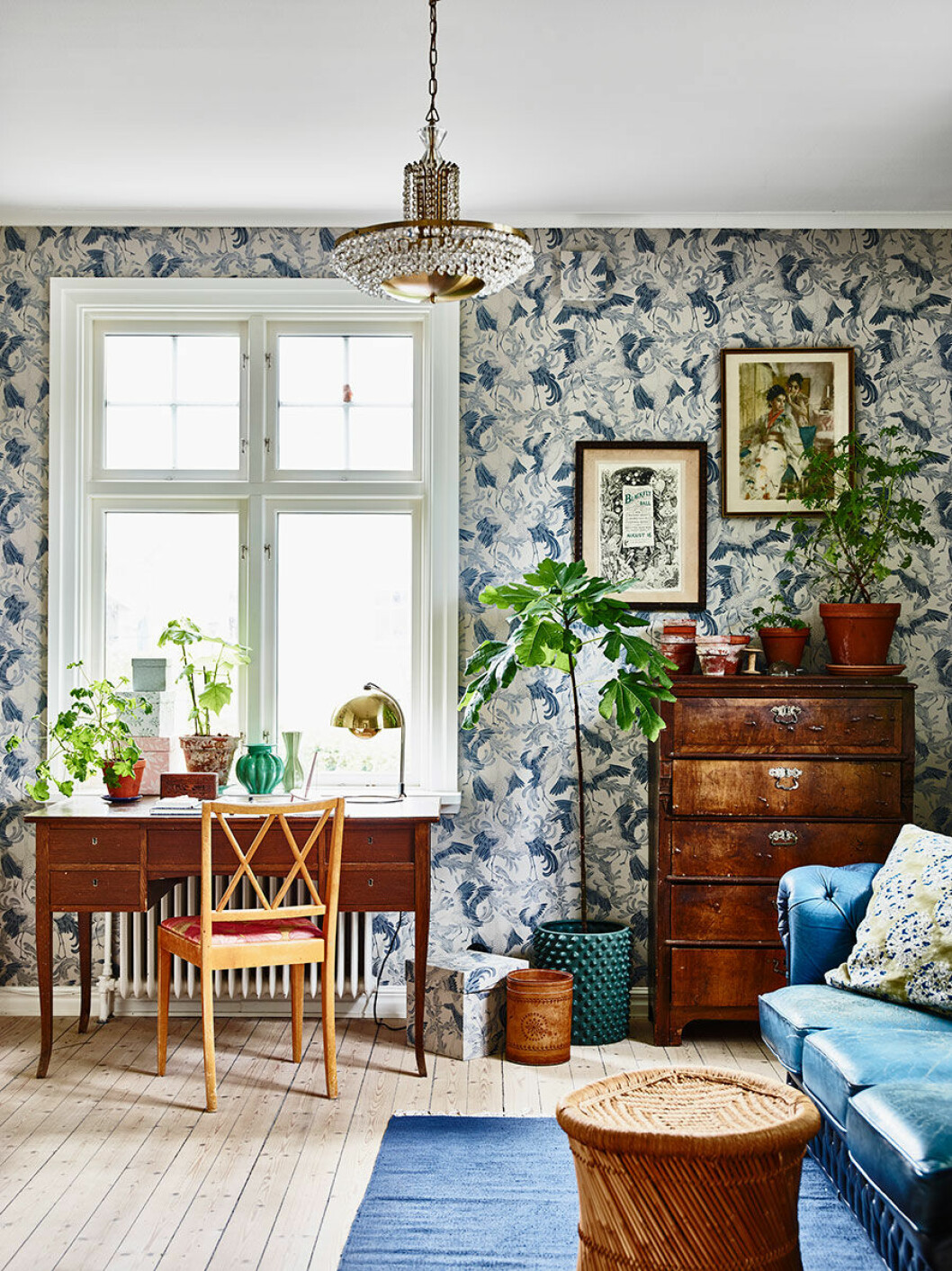 Kontoret är tapetserat med Emma von Brömssens mönster Dancing Crane, Eco Wallpaper. Både skrivbord och byrå är vintage. I taket hänger farmors gamla kristallkrona.