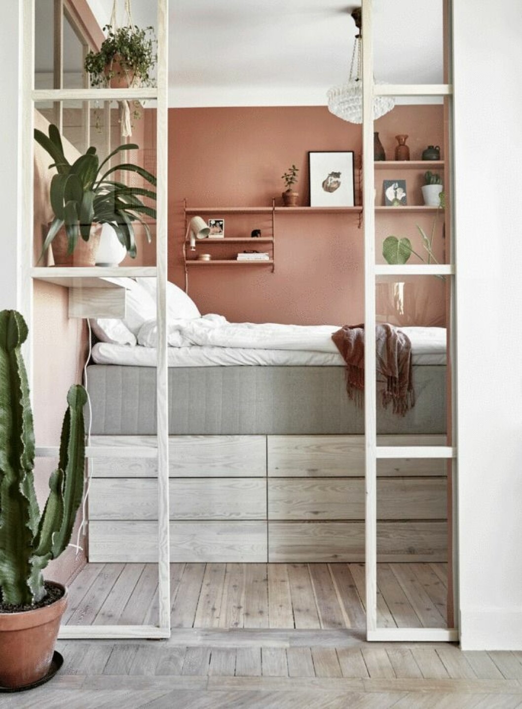 Stämningsfull sovplats i rosa med industriglas i vitt