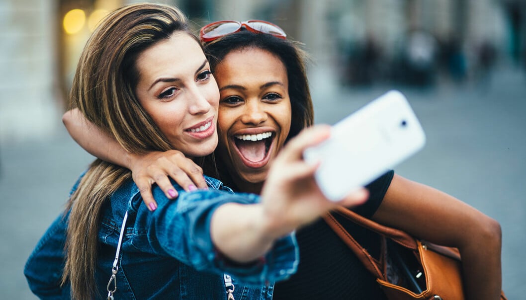 Två kvinnor poserar när de tar en selfie