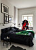 Sovrum med tavelvägg hos modedesignern Lee Cotter i lägenheten i Stockholm