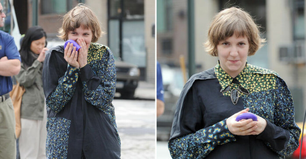 Lena Dunham döljer sina tänder genom att knipa ihop munnen.
