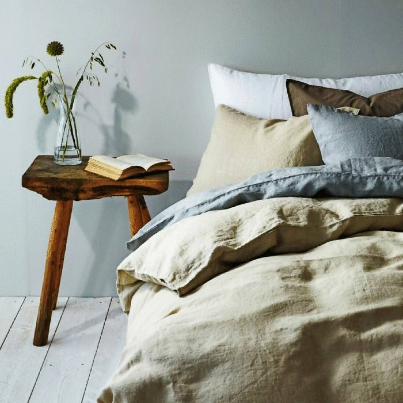 Vacker säng med sängkläder i linne