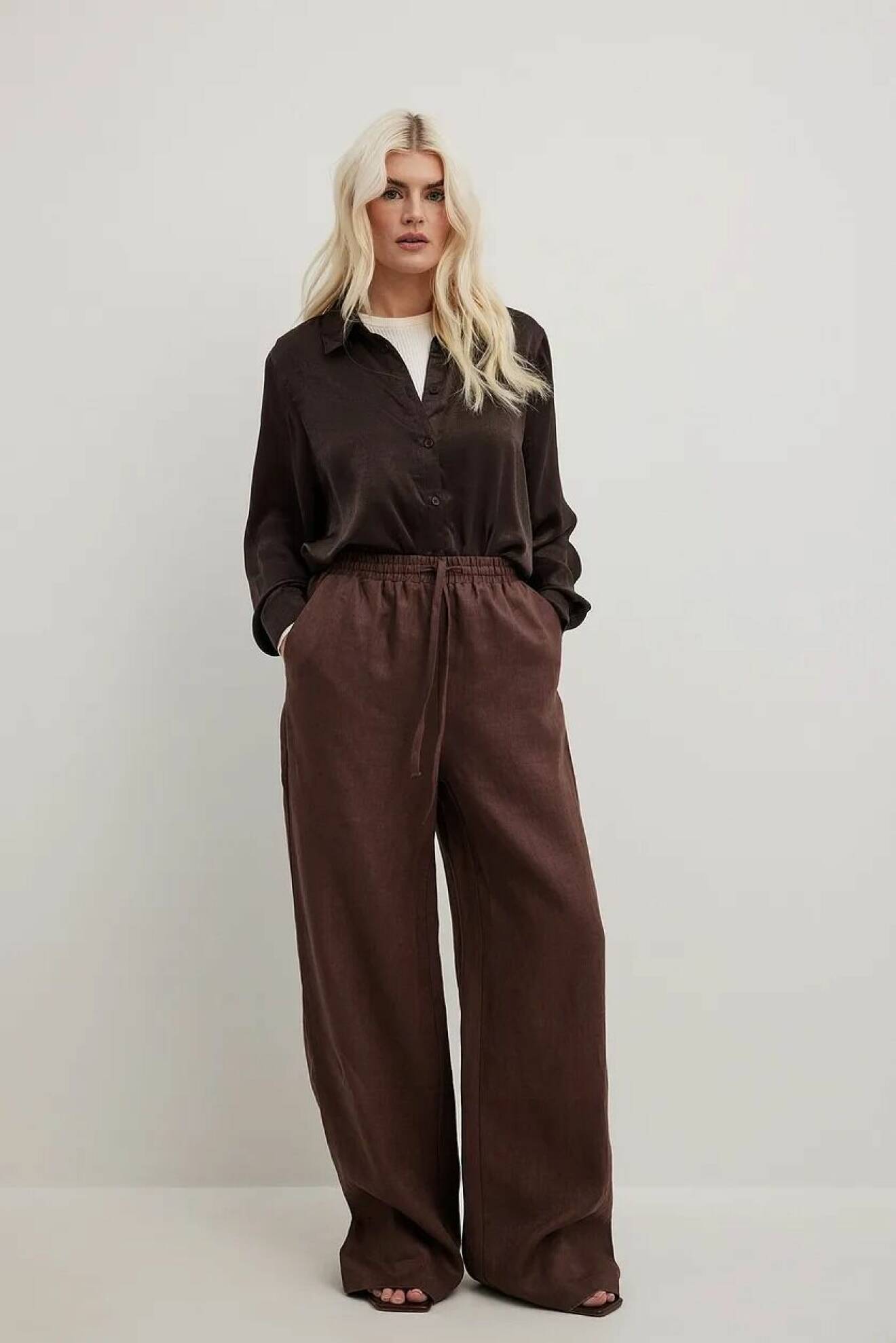 bruna byxor gjorda i linne med elastisk resor i midjan och vida ben från Na-kd