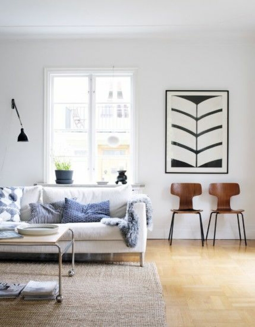 I vardagsrummet står en soffa från Eilersen. Soffbord Karin, design Bruno Mathsson, köpt på Blocket. Matta från Ikea. Vägglampan satt i Marias pappas garage. Tavlan är ett motiv av konstnären Anne Nilsson. Nedanför står två T-stolar, design Arne Jacobsen, Fritz Hansen. I vardagsrummet står en soffa från Eilersen. Soffbord Karin, design Bruno Mathsson, köpt på Blocket. Matta från Ikea. Vägglampan satt i Marias pappas garage. Tavlan är ett motiv av konstnären Anne Nilsson. Nedanför står två T-stolar, design Arne Jacobsen, Fritz Hansen.
