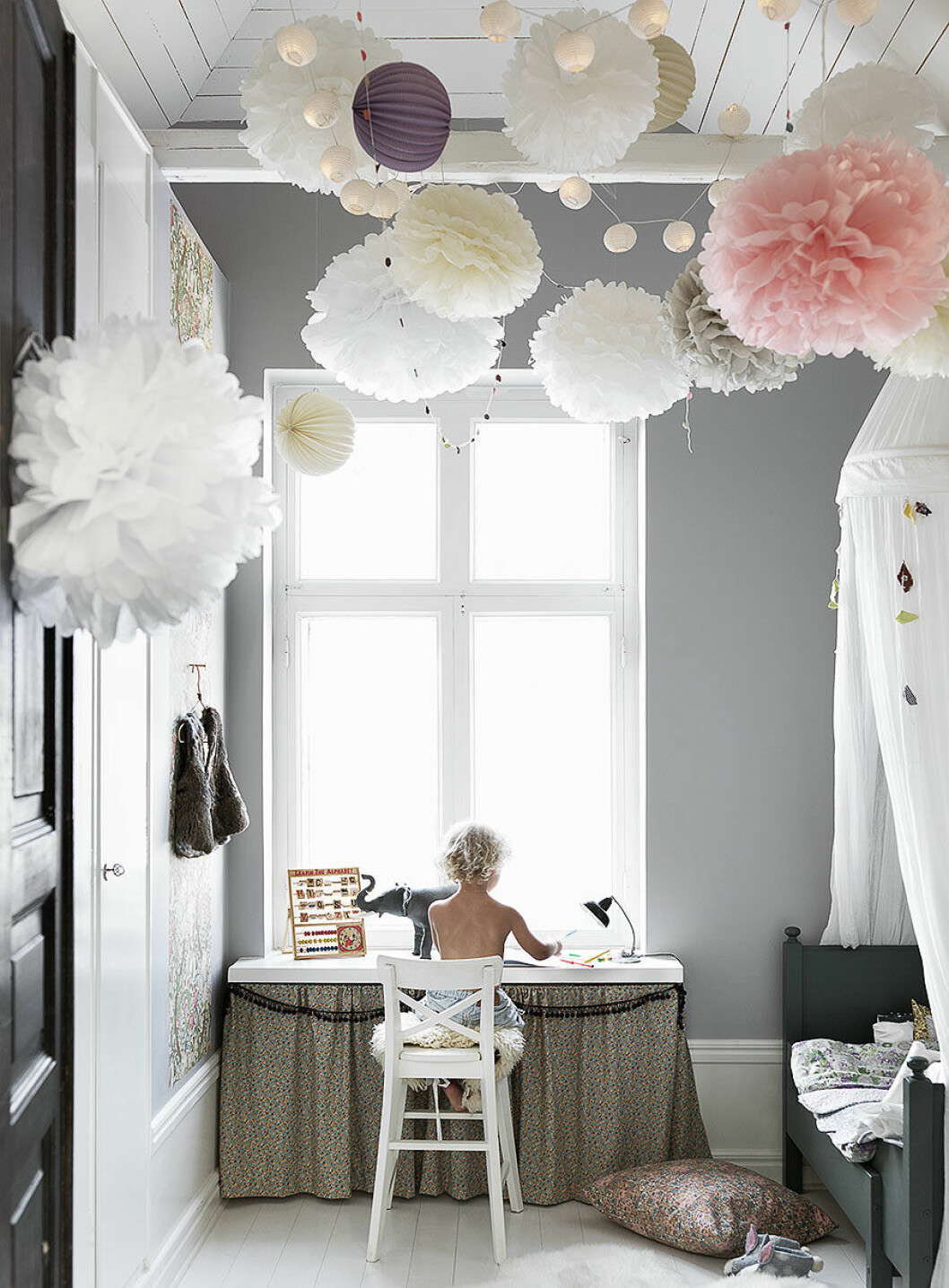 Foto: Petra Bindel, styling: Malin Persson. Bilden publicerades ursprungligen i reportaget <a href="https://www.elle.se/decoration/kika-in-i-var-bloggare-malin-perssons-ljuvliga-hem/" target="_blank" rel="noopener">”Kika in i vår bloggare Malin Perssons ljuvliga hem””</a> Barnrum med sänghimmel och dekorativa pompombollar i taket
